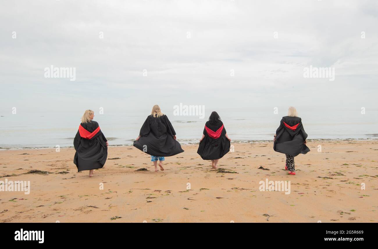 St Andrews, Scotland, UK. Soon-to-be University of St Andrews graduates Yvonne Smith, Audrey Field, Sarah Ramage and Katrina Peattie on the East Sands ahead of their graduation on Wednesday 30 June 2021. The foursome graduate as part of the Scottish Wider Access Programme.  SWAP East is a partnership between colleges and universities in the east of Scotland that aims to promote and support access to higher education for adults.  Over 1900 students will be conferred their degrees virtually this week due to Covid-19 restrictions.  Photo by Gayle McIntyre Stock Photo