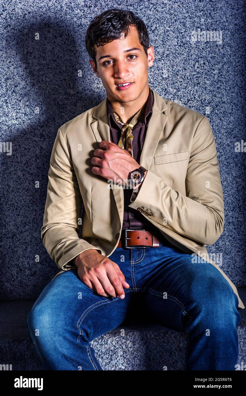Young Man Fashion. A young man, wearing a beige blazer, blue jeans, a  little scarf, and a wristwatch, is sitting there, looking at you Stock  Photo - Alamy