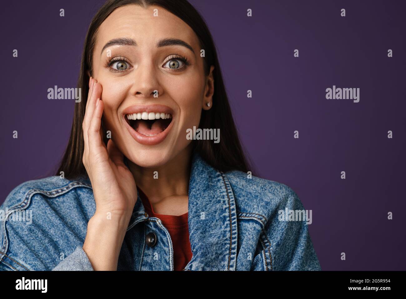 Excited beautiful brunette girl expressing surprise at camera isolated ...