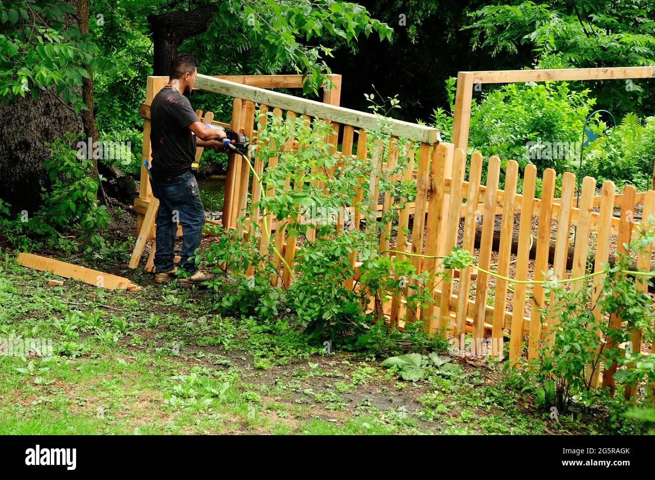 Worker constructing back yard fence Stock Photo
