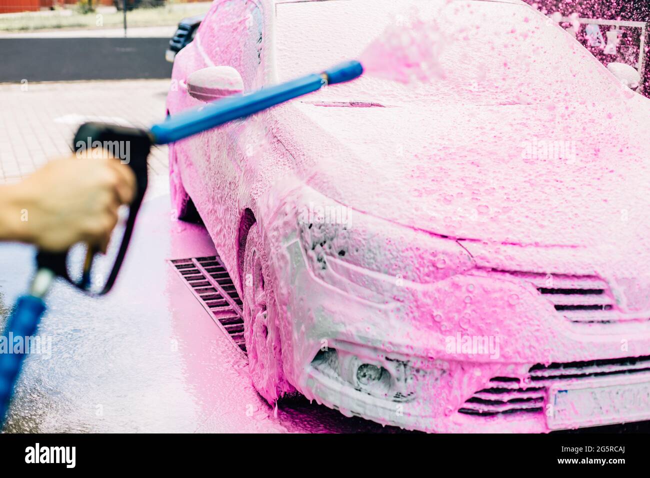 Manual car wash with pressurized water in car washes, a person washes