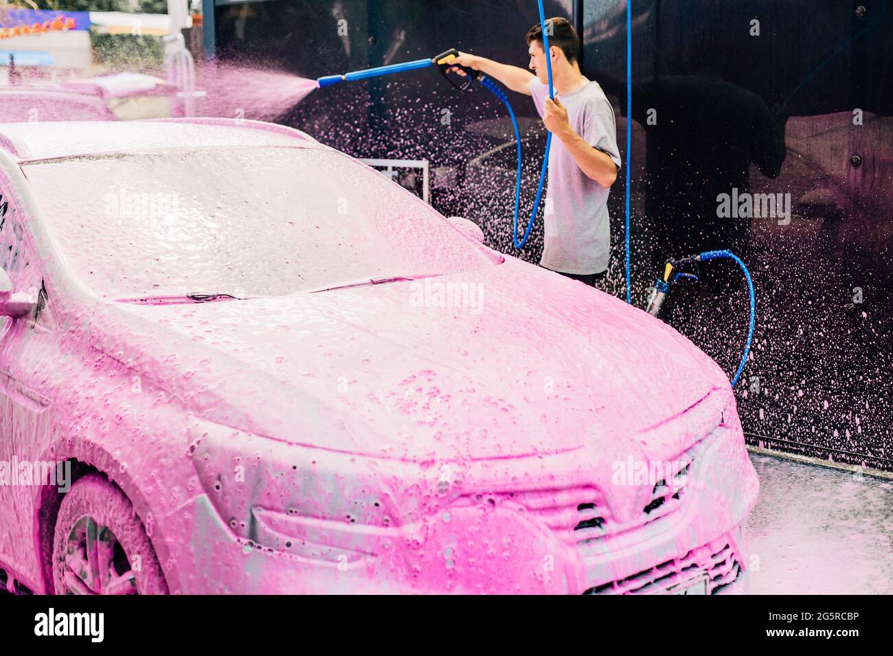 Manual car wash with pressure water on the street, Summer car wash, Car