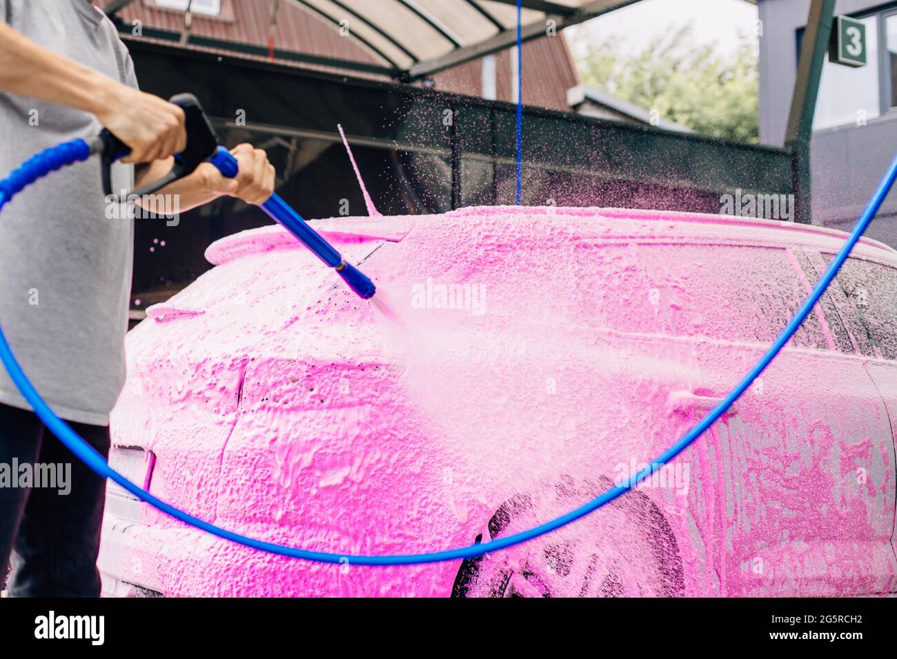 Car wash with soap, Car cleaning with high pressure water, a man washes