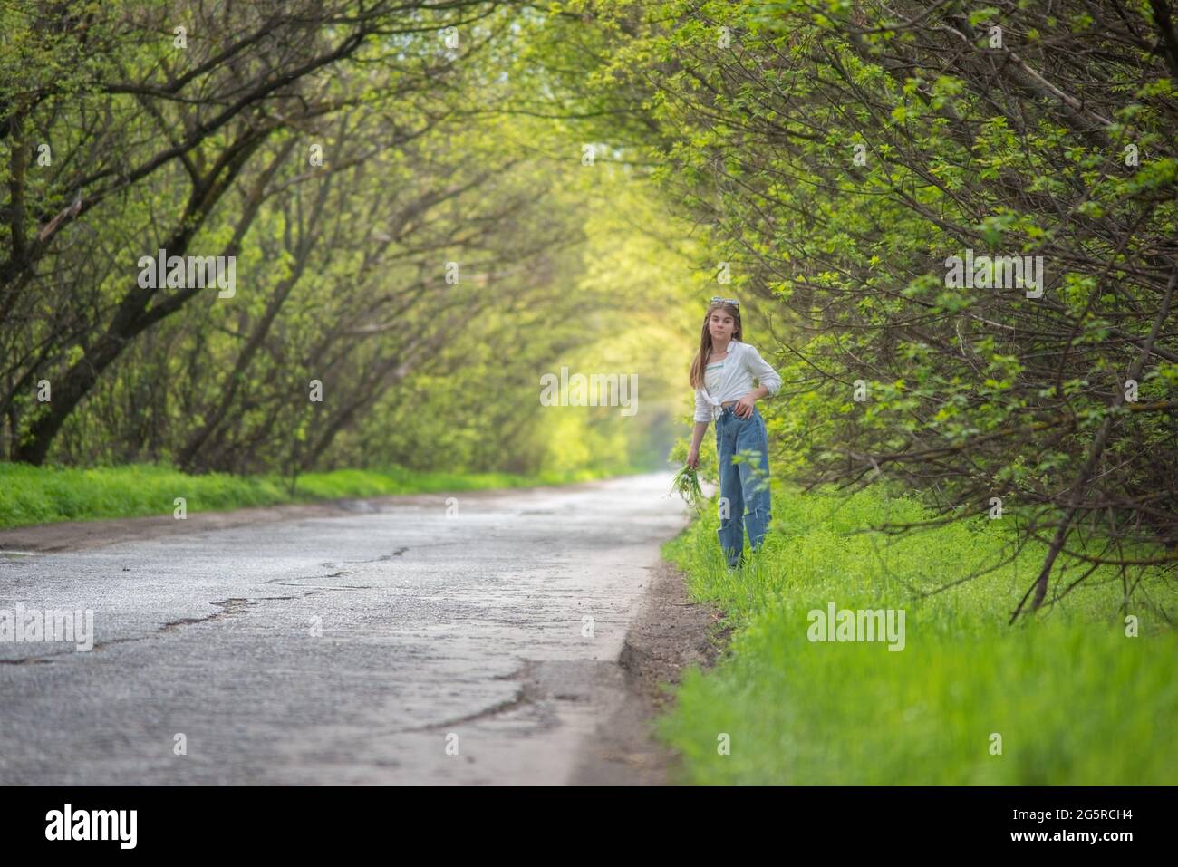 fashionable little girl standing walking on the road against the ...