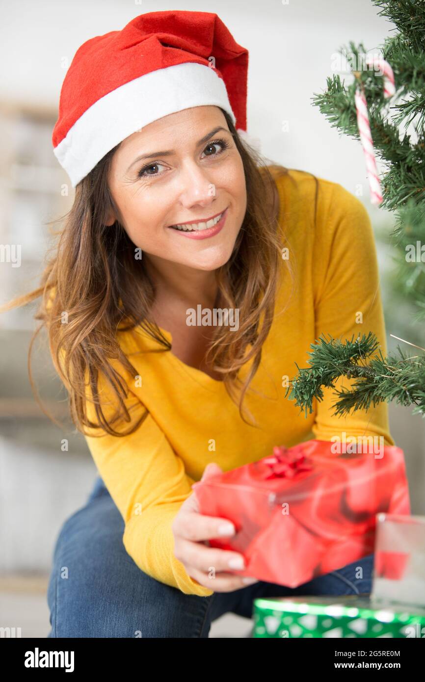 woman wearing a santa hat and holding a present Stock Photo