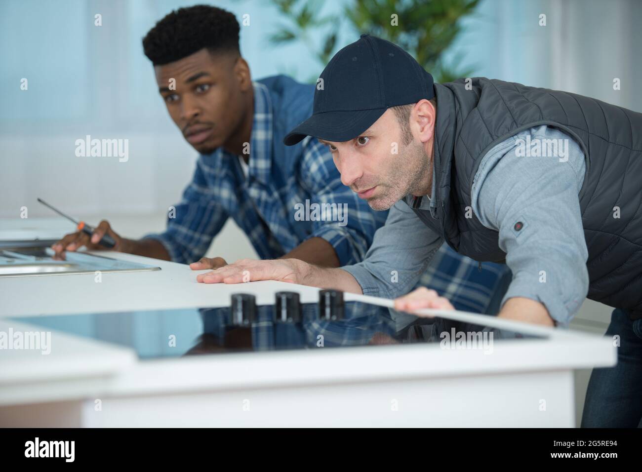 two men fitting a new kitchen Stock Photo