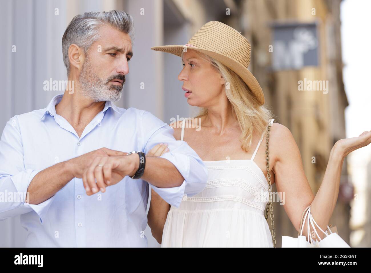 woman and man finger pointing to his watch Stock Photo