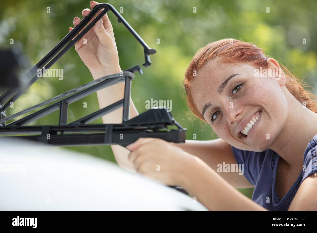 woman fixing a car roof rack outdoors Stock Photo Alamy