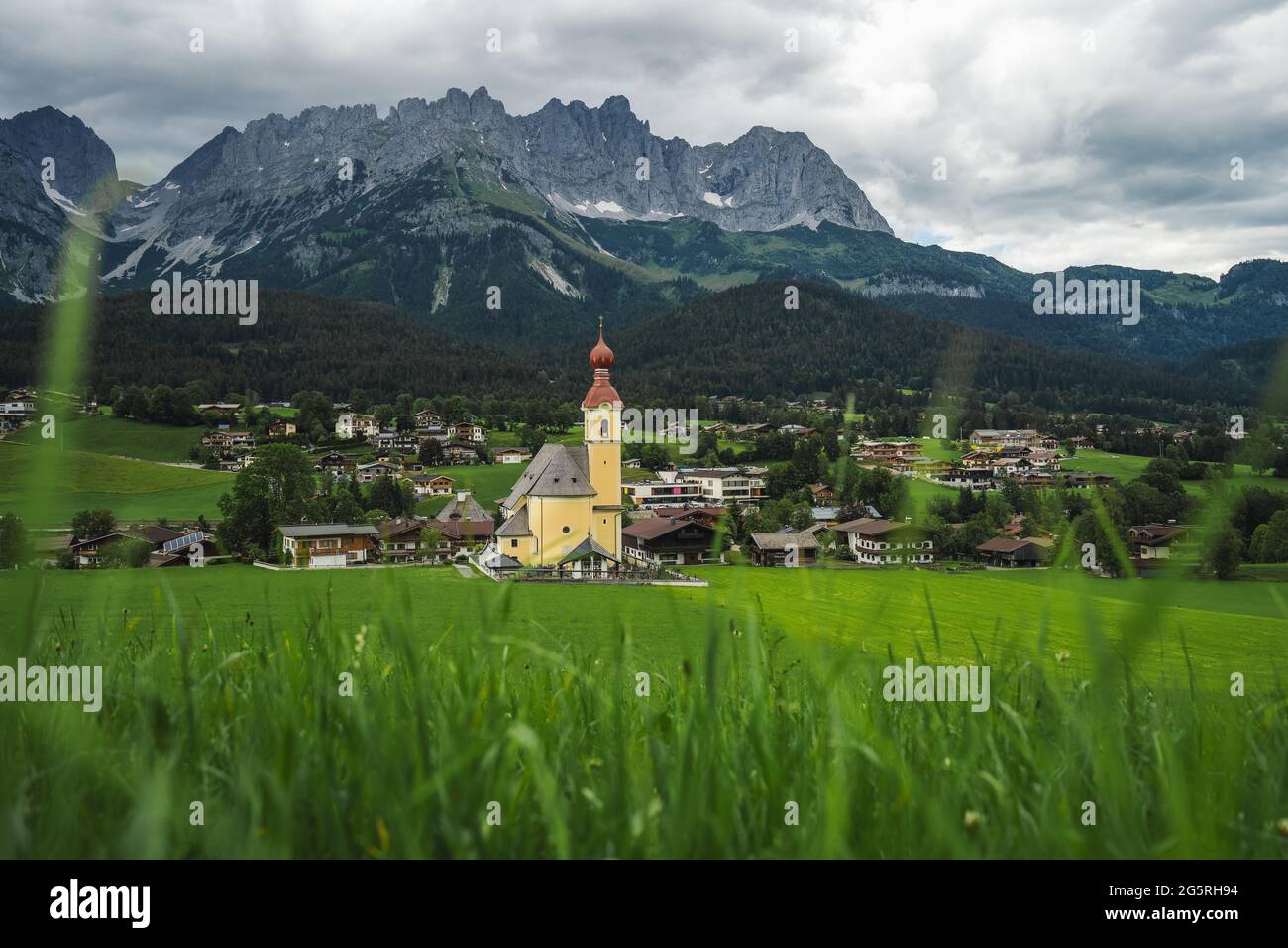 Yellow local church in Ellmau. Village of Going. Wilden Kaiser mountains in background. Tirol, Alps, Austria Stock Photo