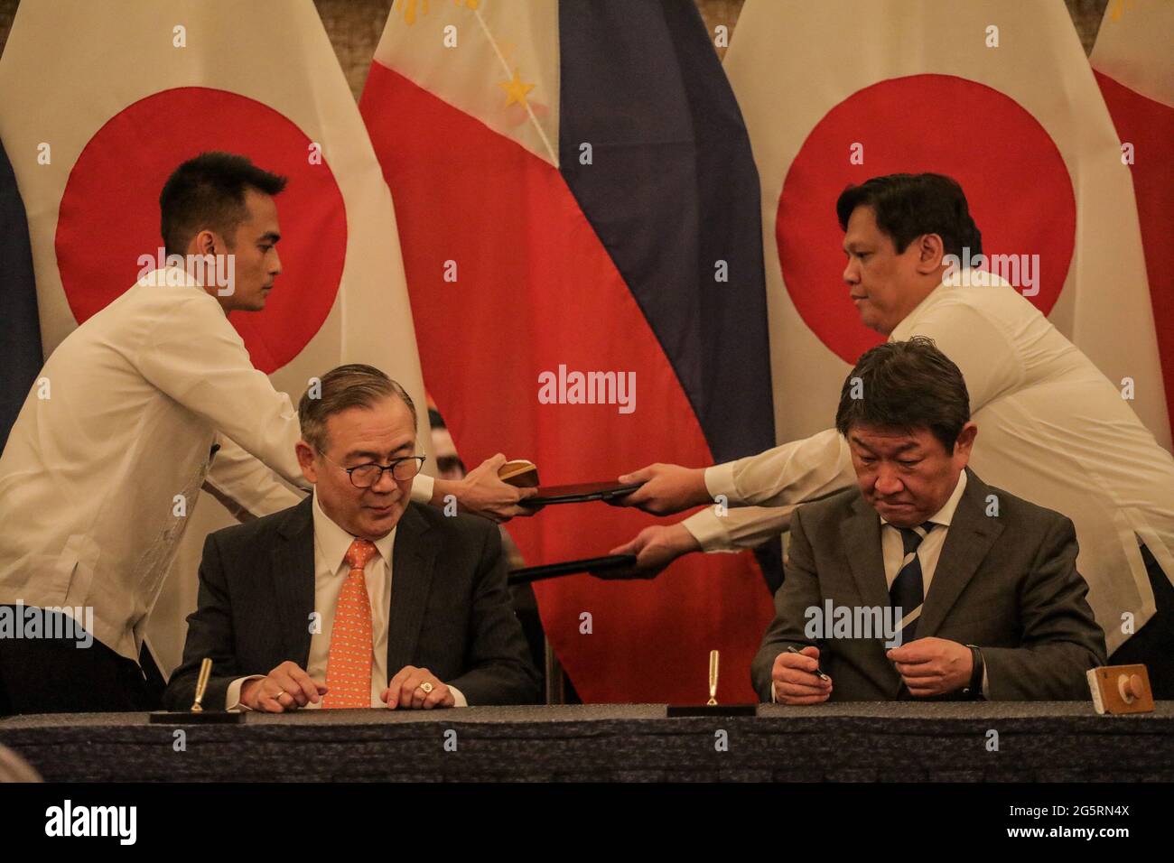 Philippine Foreign Affairs Secretary Teodoro Locsin, Jr., left, exchanges agreements with his Japanese counterpart Toshimitsu Motegi after their bilateral meeting in Manila, Philippines. Stock Photo