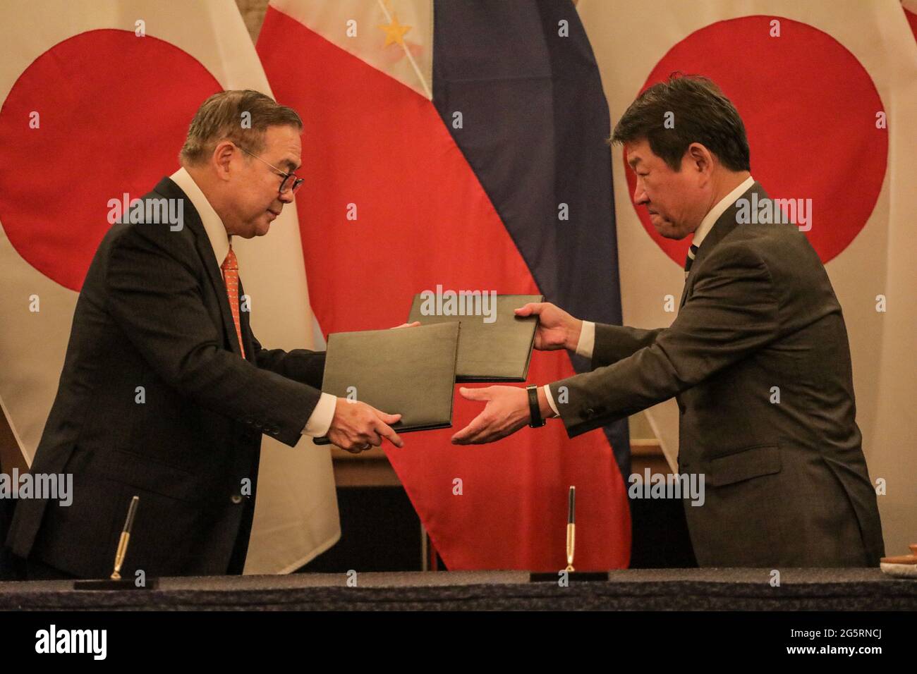 Philippine Foreign Affairs Secretary Teodoro Locsin, Jr., left, exchanges agreements with his Japanese counterpart Toshimitsu Motegi after their bilateral meeting in Manila, Philippines. Stock Photo
