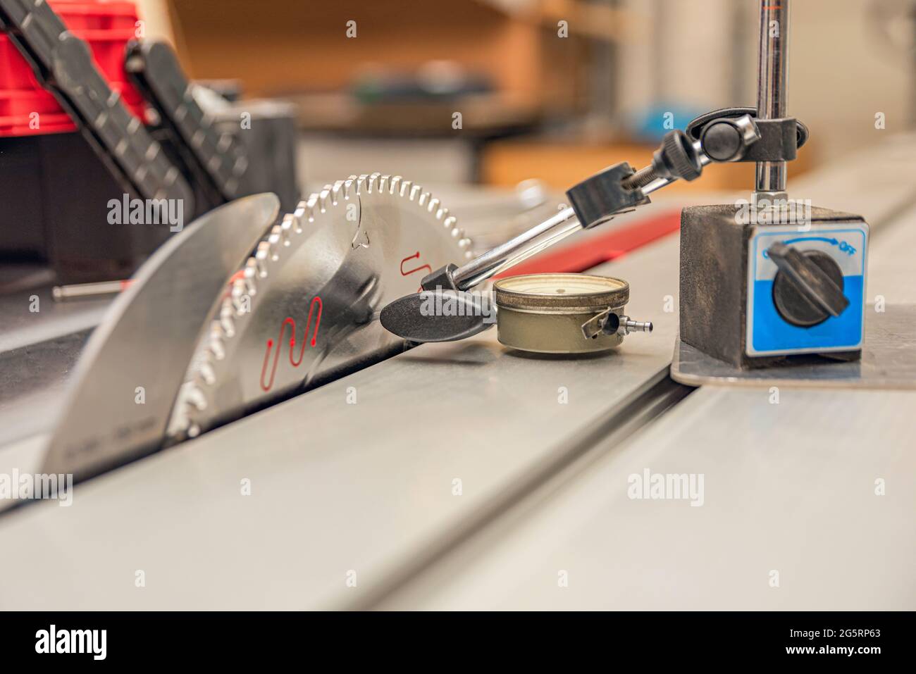 Dial indicator. A worker adjusts a scale indicator to align a saw blade