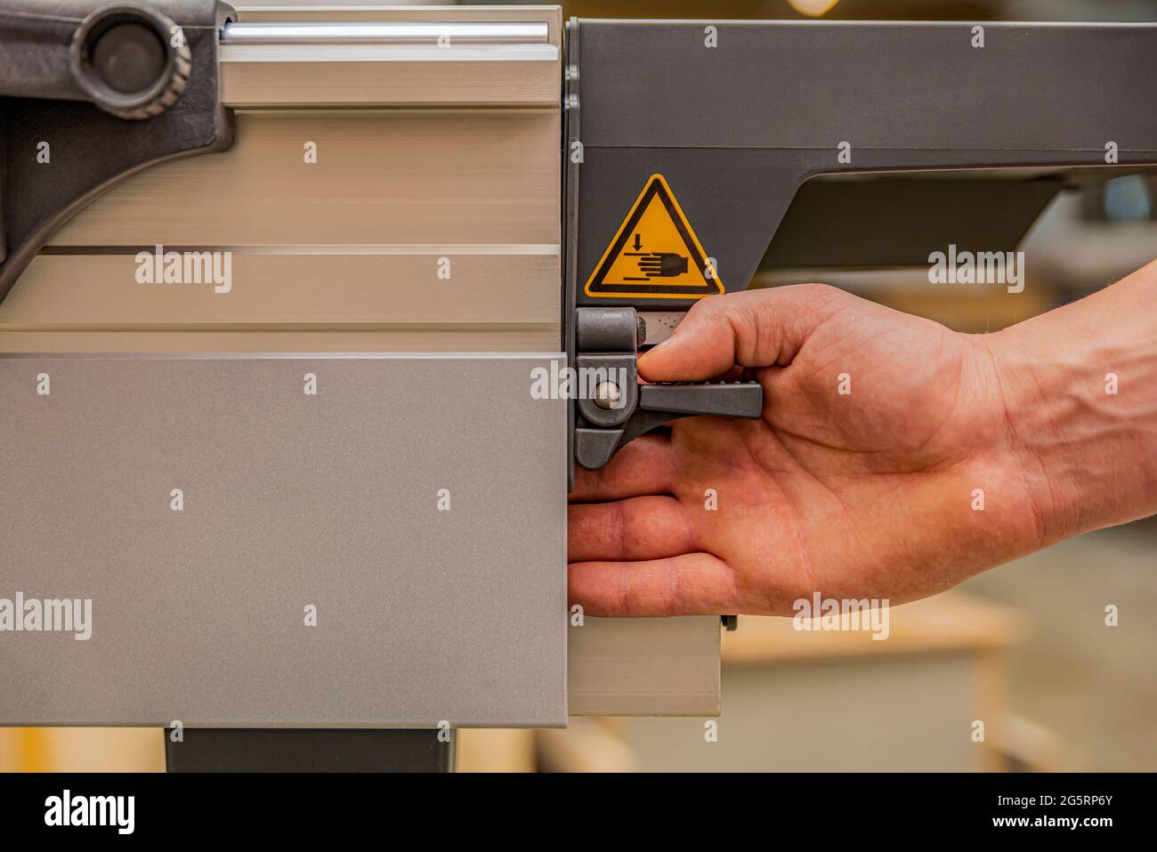 Industrial safety engineering. Compliance with safety rules when using machine tools in production, warning sign, yellow triangle, hand symbol on a Stock Photo