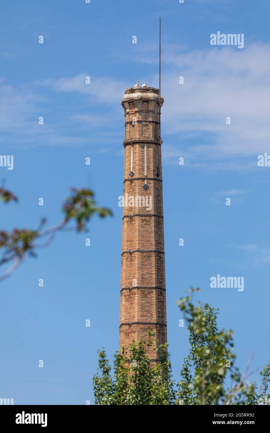 Segovia, Spain - June 2, 2021: Old industrial chimney of the old pottery factory in Segovia, next to the Eresma river, now inhabited by storks Stock Photo