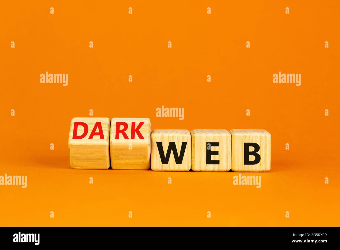 Dark web symbol. Turned wooden cubes and changed the word web to dark web. Beautiful orange background. Business, dark web concept. Copy space. Stock Photo