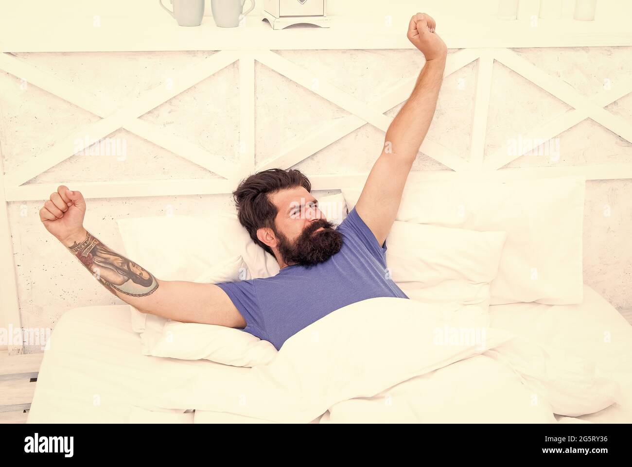 Nice morning. lazy sunday. bed time routine. brutal male stretching. relax lifestyle concept. bearded man in bed. early wake up at morning. bachelor Stock Photo