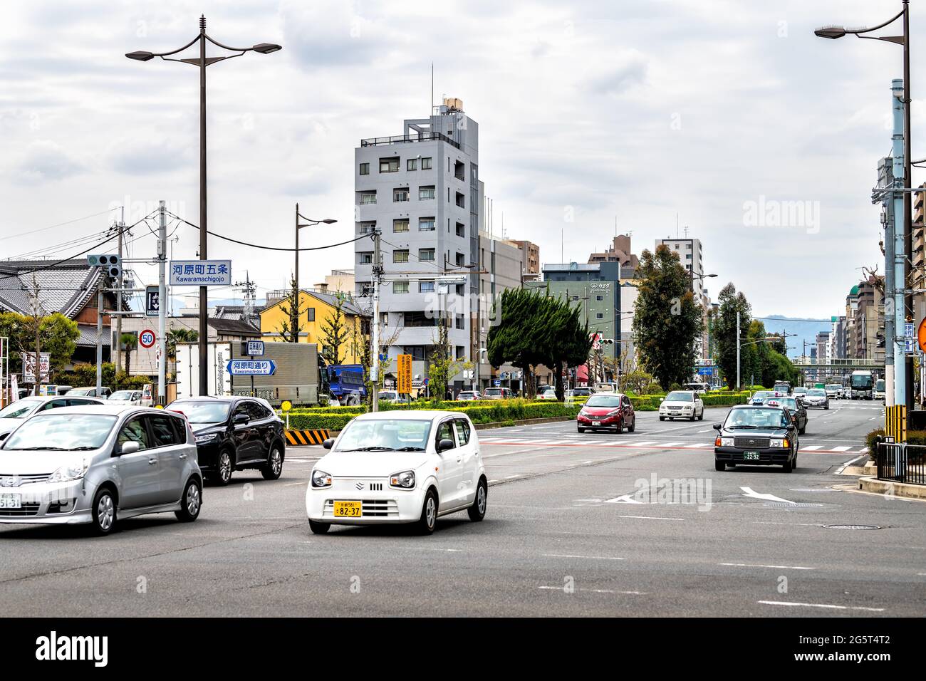 Kyoto, Japan - April 17, 2019: Taxi cars in traffic on road with kawaramachi street sign and English translation in busy downtown city Stock Photo