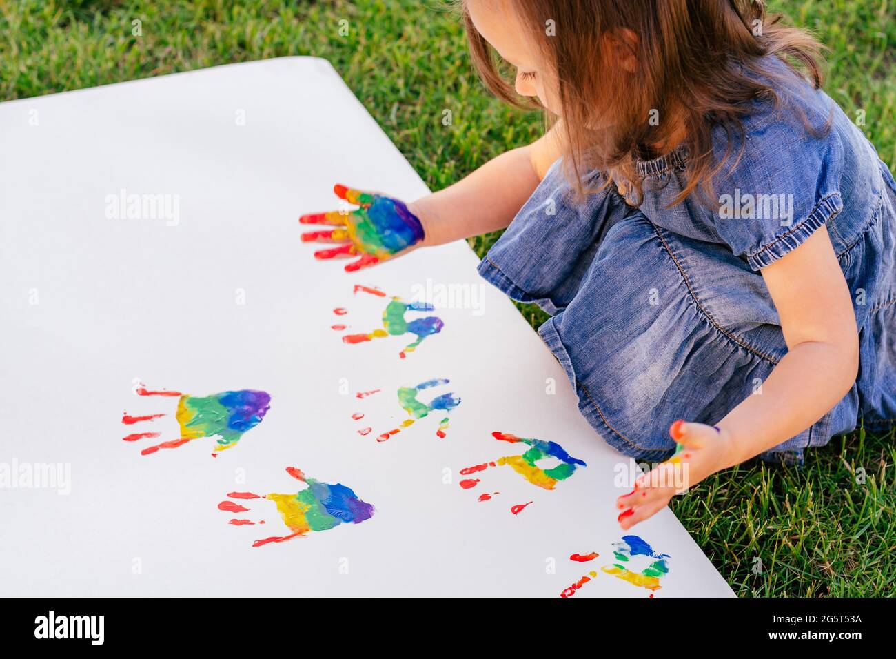 Kids painting together on a large piece of paper Stock Photo - Alamy