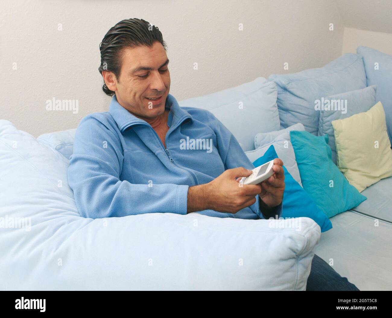 man sitting on the sofa with PDA Stock Photo