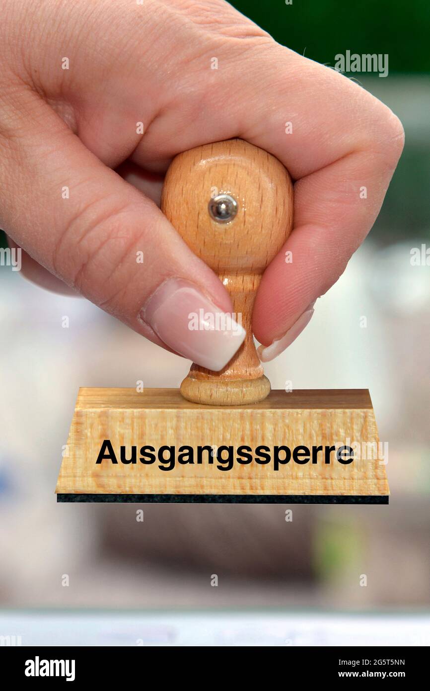 woman's hand with stamp with the label Ausgangssperre, lockdown Stock Photo