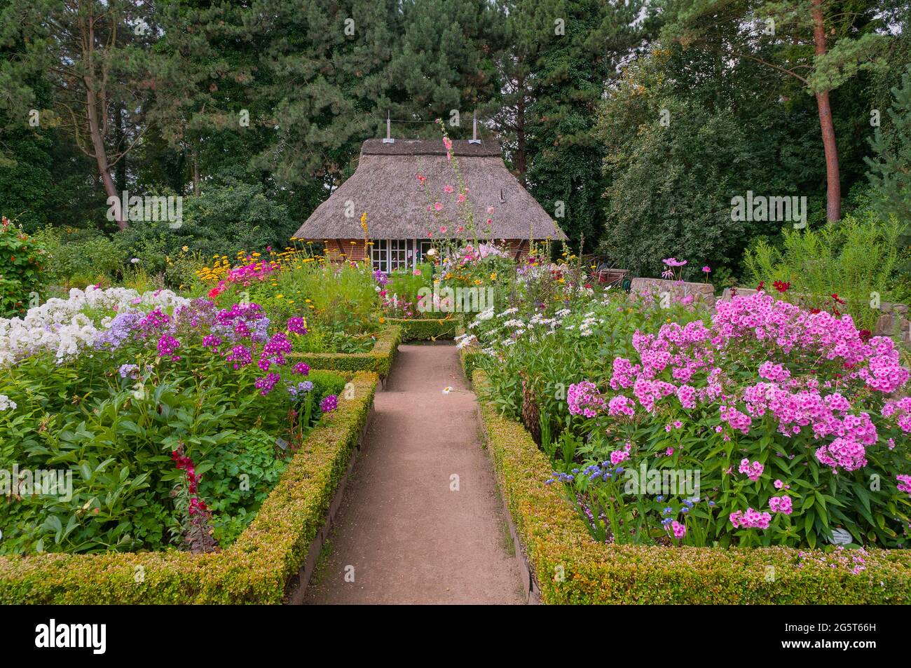 flowerbeds and thatched-roof house at the Botanical Gardens Hamburg-Flottbek, Germany, Hamburg Stock Photo