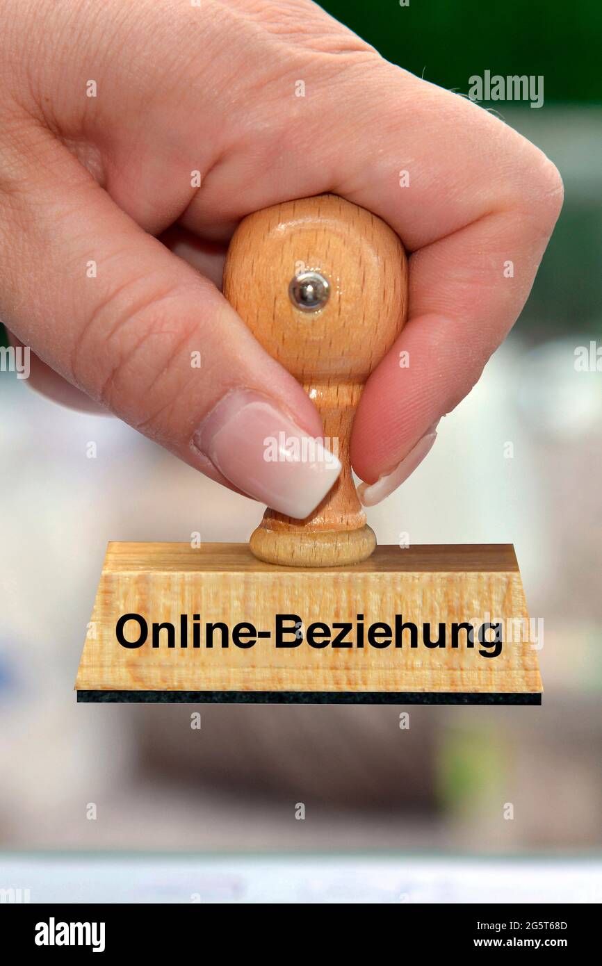 woman's hand with stamp with the label Online-Beziehung, Online-Relationship Stock Photo