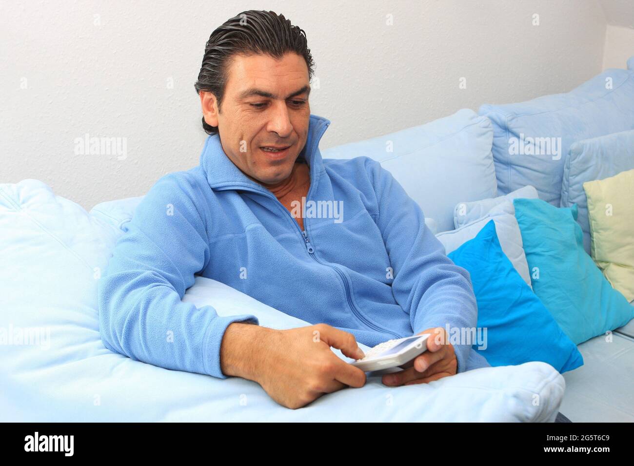 man sitting on the sofa with PDA Stock Photo