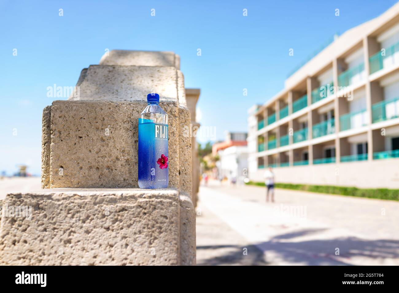 Hollywood, USA - May 6, 2018: Beach broadwalk promenade in Florida at sunny day and Fiji water bottle with condensation drops on plastic illustrative Stock Photo