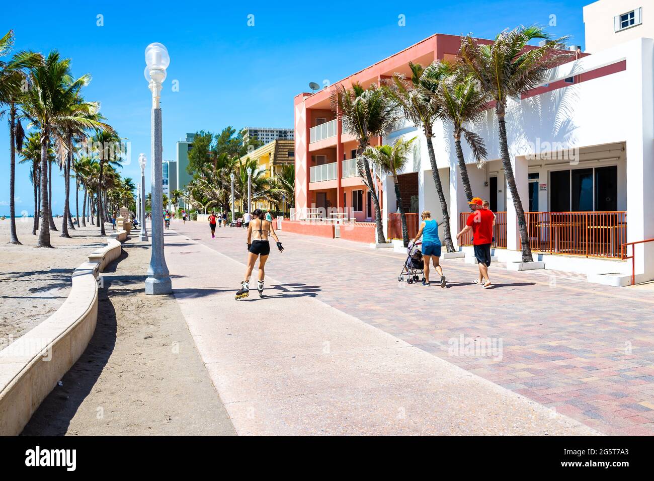 Hollywood, USA - May 6, 2018: Beach broadwalk in Florida with sunny day and people on promenade coast roller blading skating on bicycle lane Stock Photo