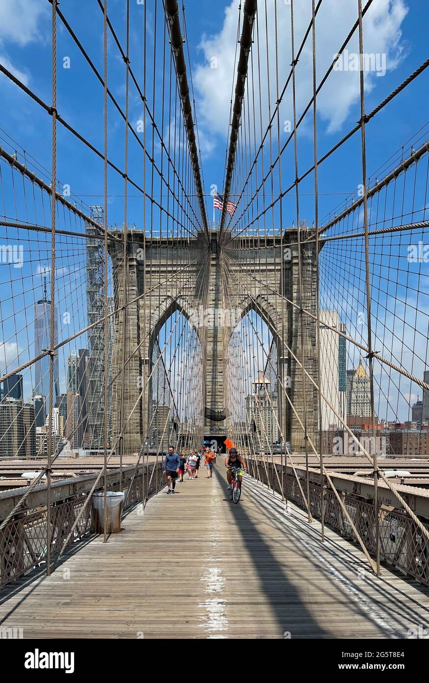 The walkway across the Brooklyn Bridge in New York city has separate lanes for pedestrian walkers and bicyclists. Stock Photo
