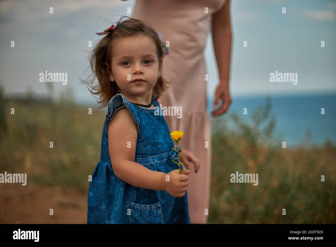 Close-up portrait of a child girl holding a dandelion Stock Photo - Alamy