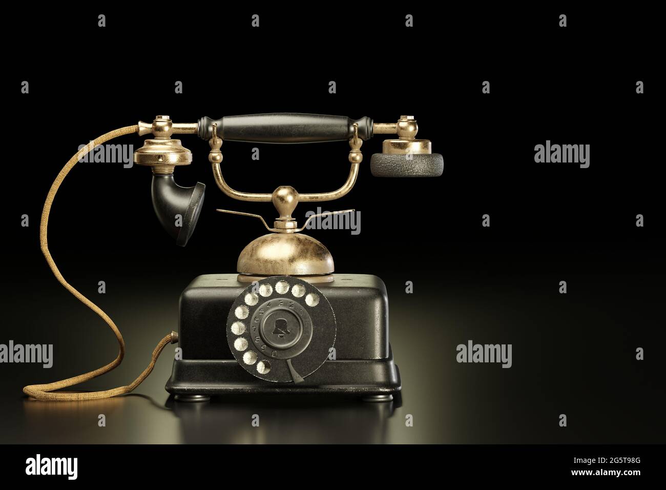 Vintage brass and black iron telephone in dark background. It was a communication antique tool in the past that used a dial to call each other. Copy s Stock Photo