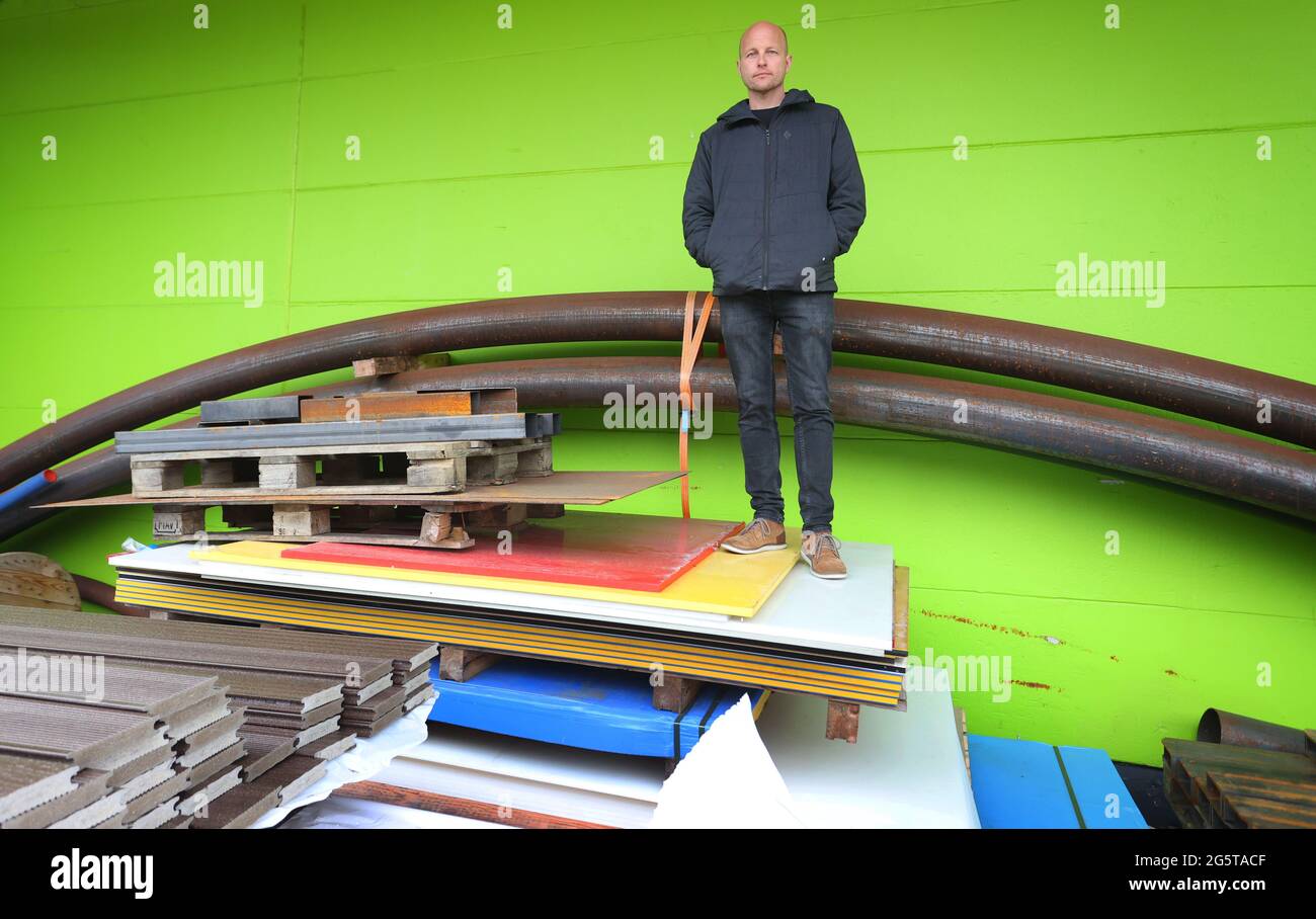 Durach, Germany. 06th May, 2021. Dirk Scheumann, managing director of the pumptrack manufacturer 'Schneestern', stands in front of his company's production hall among building materials. In more and more German cities, asphalt facilities like this are springing up, and it's not just cyclists who are having fun on them. Credit: Karl-Josef Hildenbrand/dpa/Alamy Live News Stock Photo