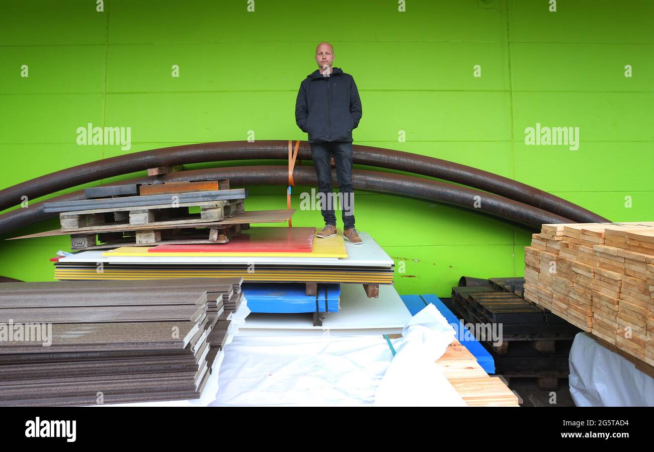 Durach, Germany. 06th May, 2021. Dirk Scheumann, managing director of the pumptrack manufacturer 'Schneestern', stands in front of his company's production hall among building materials. In more and more German cities, asphalt facilities like this are springing up, and it's not just cyclists who are having fun on them. Credit: Karl-Josef Hildenbrand/dpa/Alamy Live News Stock Photo