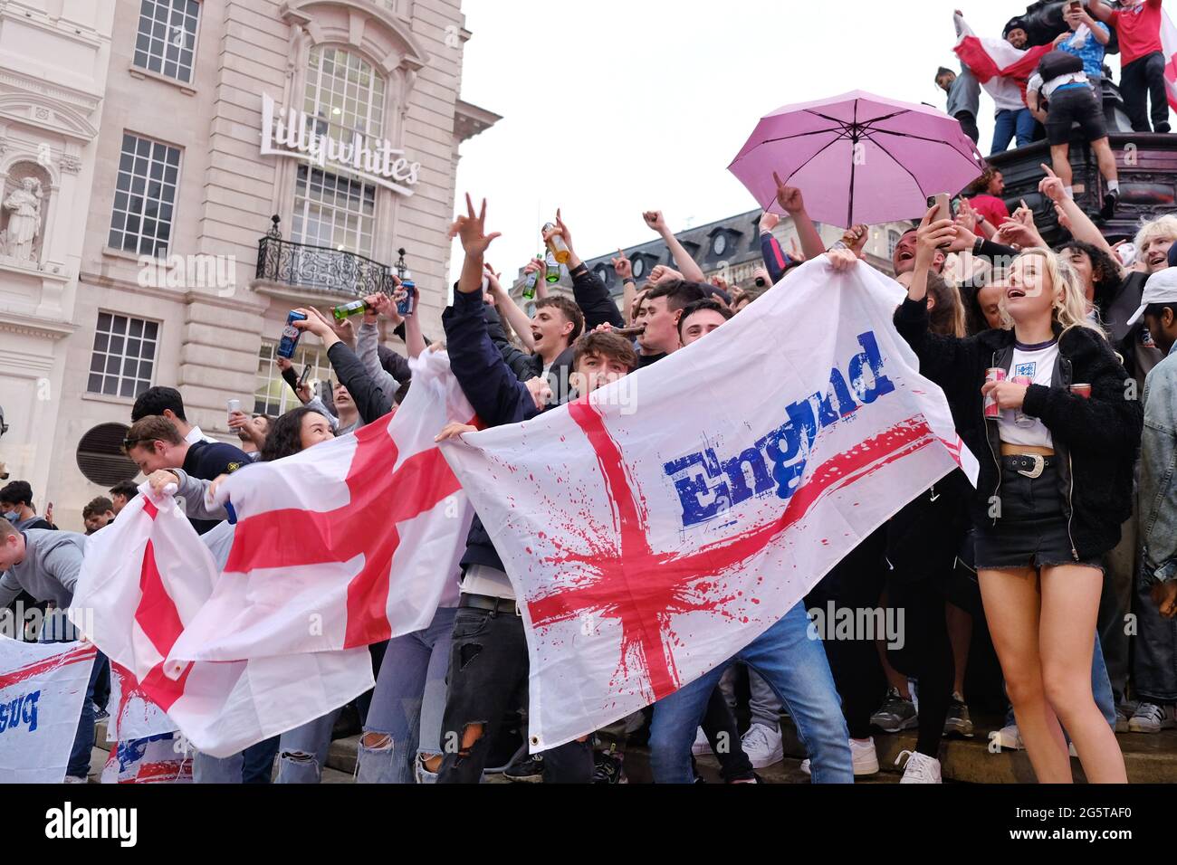 England fans celebrate into the evening at Piccadilly Circus after the team's historic 2-0 win against Germany in the Euro 2020 tournament. Stock Photo