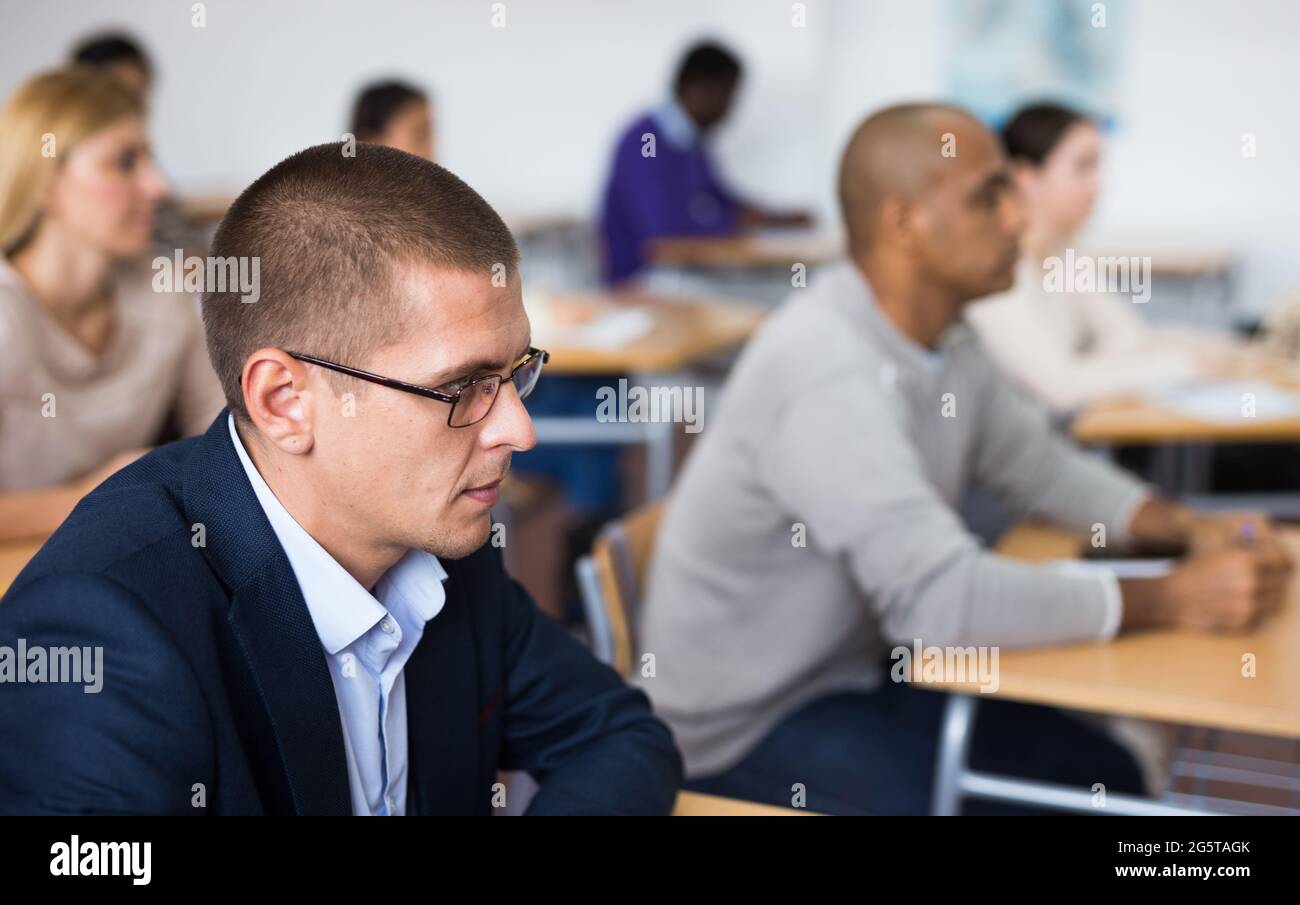 Attentive students at their desks in university auditorium Stock Photo