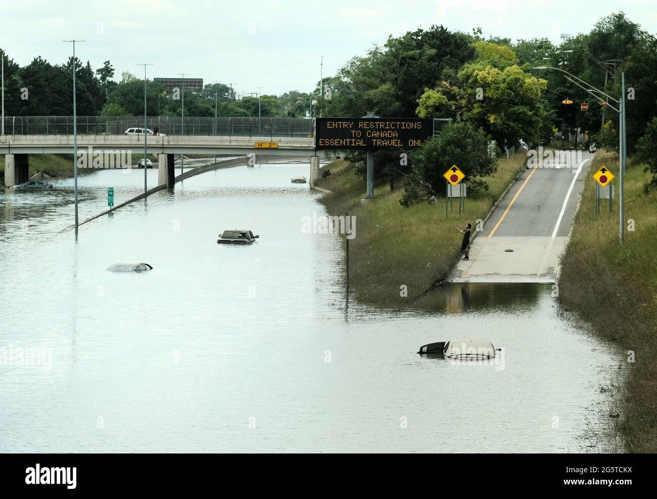 Detroit residents observe a stretch of I-94 that is still under several feet of water following heavy weekend rains which flooded parts of Metro Detroit. After a weekend of heavy storms beginning on Friday night and lasting through the weekend rainwater flooded parts of I-94 in Detroit, Michigan forcing some motorists to abandon their vehicles and seek shelter from the heavy rains. Flood waters remained in areas along I-94 between Dearborn and Downtown Detroit several days later as Michigan Governor Gretchen Whitmer held a press conference on the still inundated I-94. (Photo by Matthew Hatcher Stock Photo