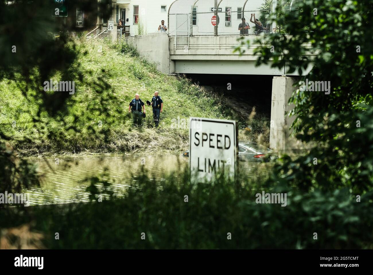 Detroit Police inspect a vehicle that is stuck in flood waters on a portion of I-94 that flooded during a week of heavy rain which saw some motorists abandoning their vehicles to escape the rising water. After a weekend of heavy storms beginning on Friday night and lasting through the weekend rainwater flooded parts of I-94 in Detroit, Michigan forcing some motorists to abandon their vehicles and seek shelter from the heavy rains. Flood waters remained in areas along I-94 between Dearborn and Downtown Detroit several days later as Michigan Governor Gretchen Whitmer held a press conference on t Stock Photo