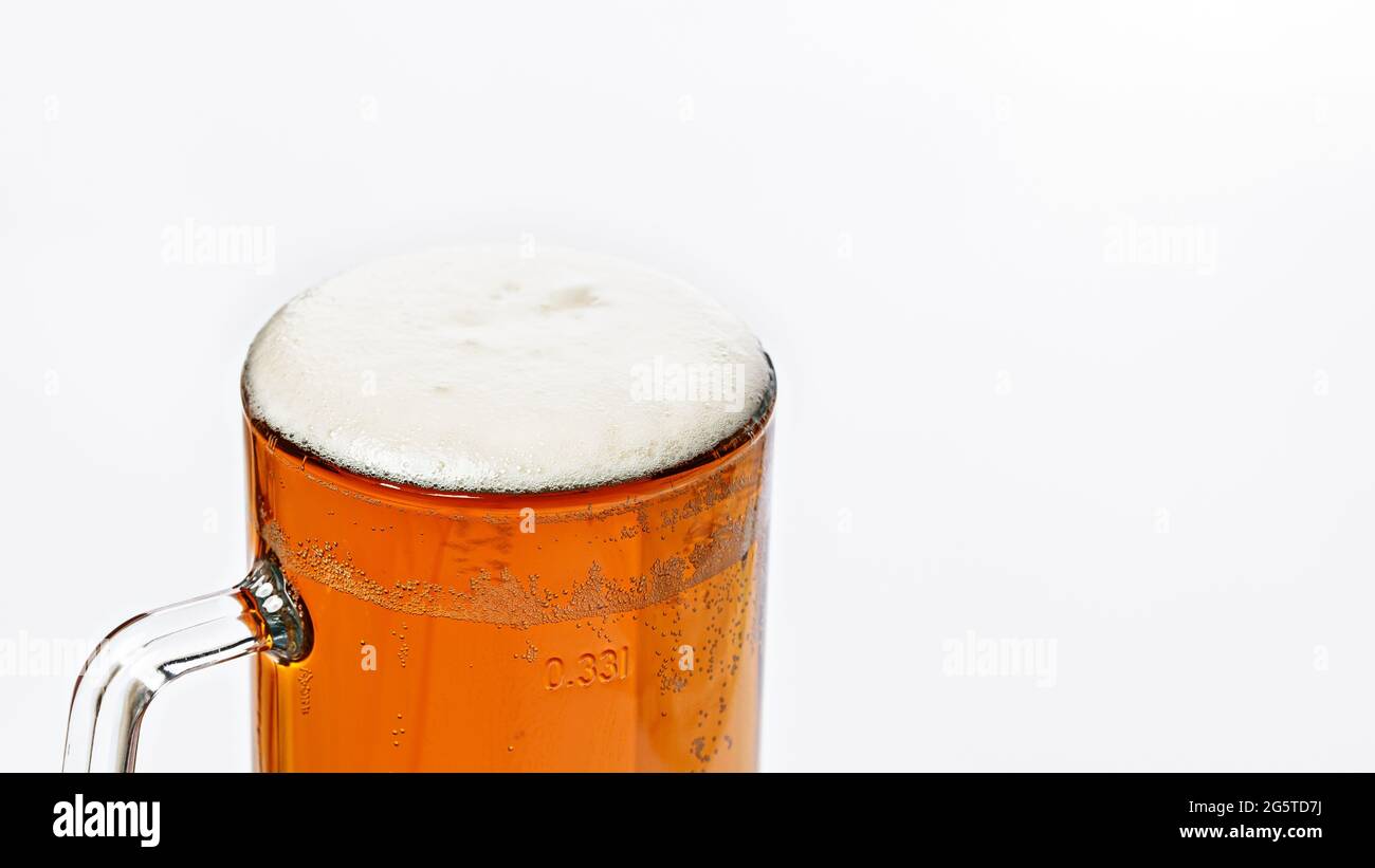 Mug of cold light beer on a white background. Beer foam and bubbles. Traditional light alcoholic drink shot. Close-up. Copy space Stock Photo