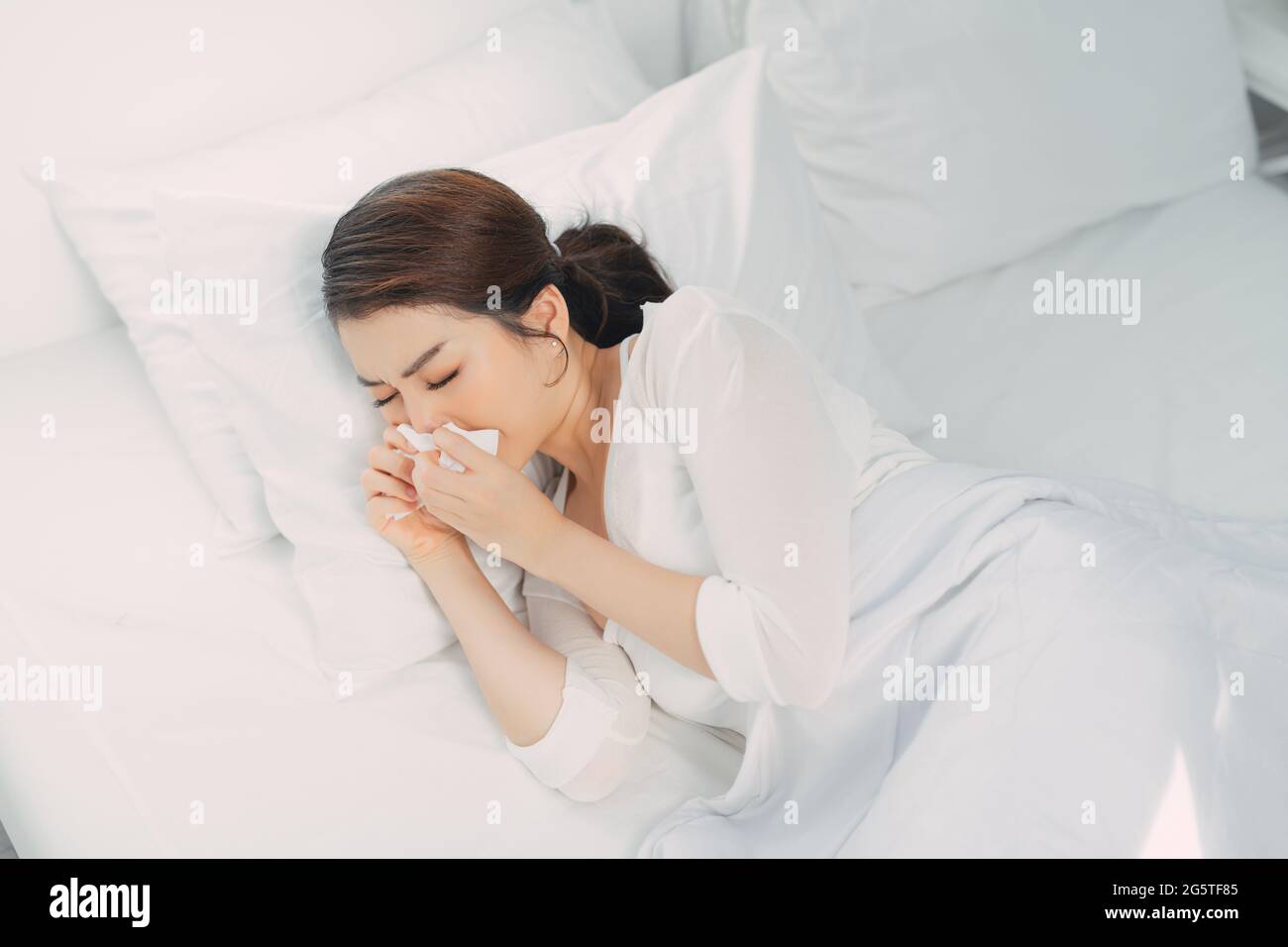 Sick woman suffering from running stuffy nose and sore throat Stock