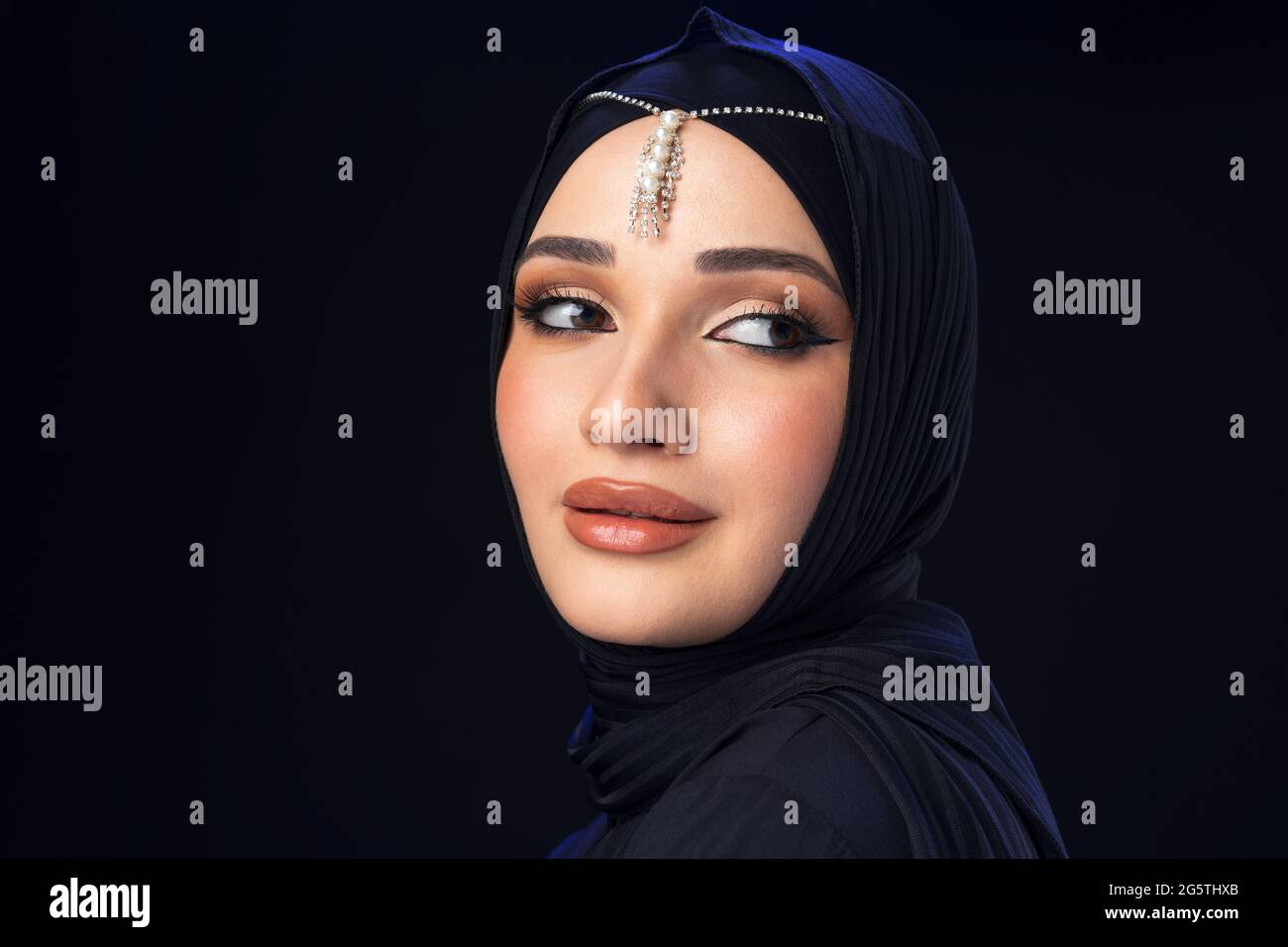 Portrait of a young muslim woman in hijab on black background Stock ...