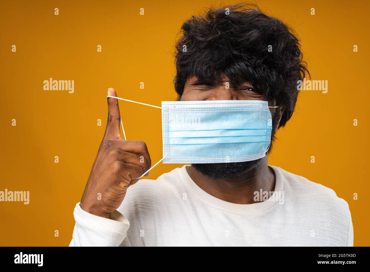 Positive handsome african american man with medical mask against yellow ...