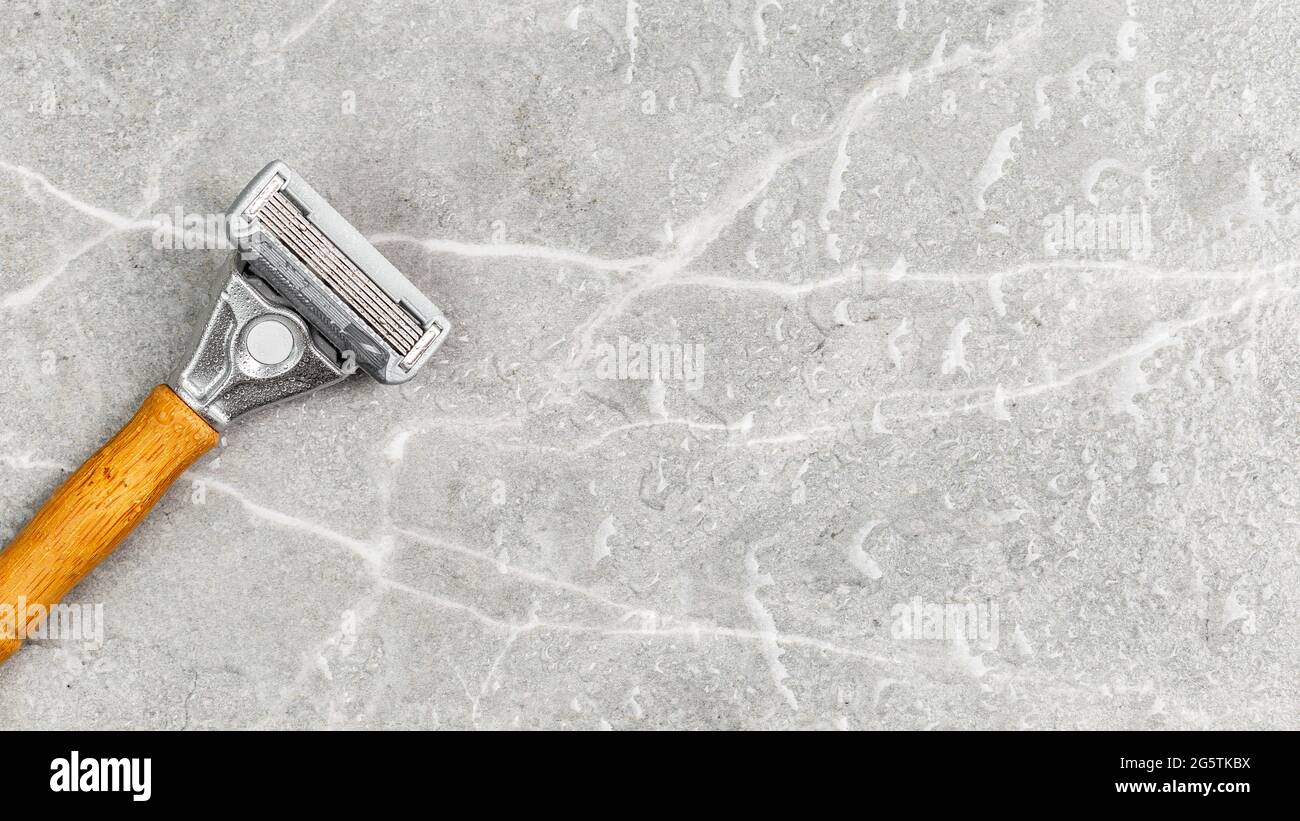 Wet shaving Razor with five blades head and wooden handle on a grey marble background. Copy Space for text Stock Photo