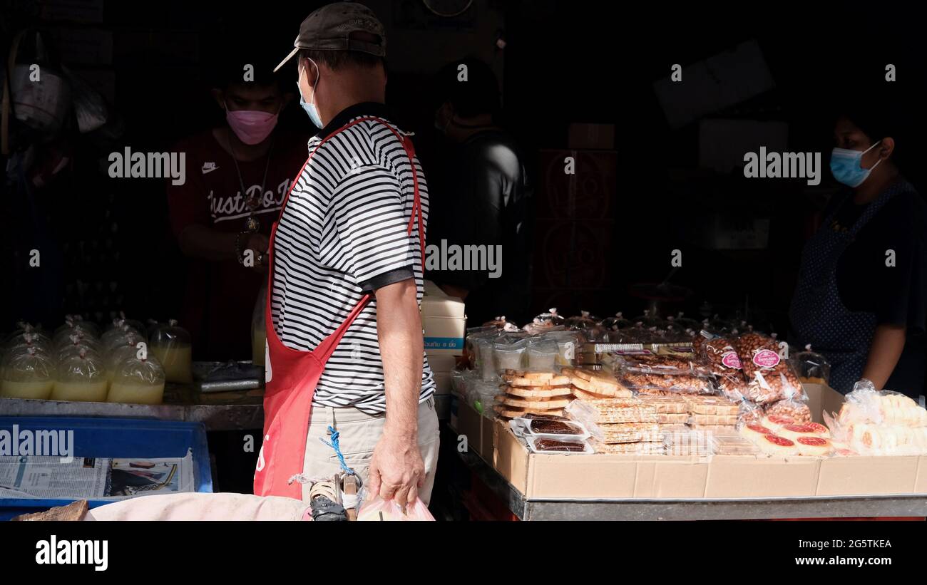 Man Selling Baked Goods Klong Toey Market Wholesale Wet Market Bangkok Thailand largest food distribution center in Southeast Asia Stock Photo