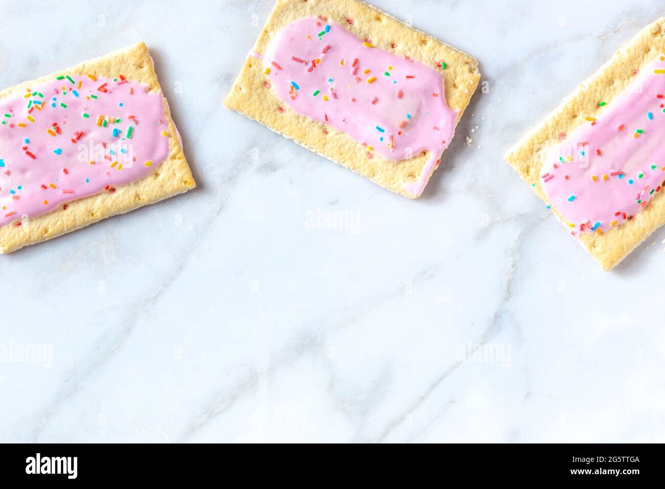 Pink pop tarts, shot from the top on a white marble background with a place  for text Stock Photo - Alamy