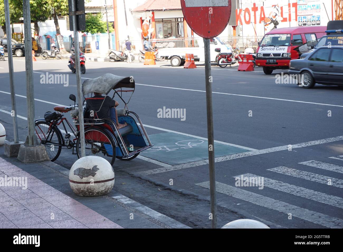 Becak on the side walk. Becak is one of traditional indonesian ...
