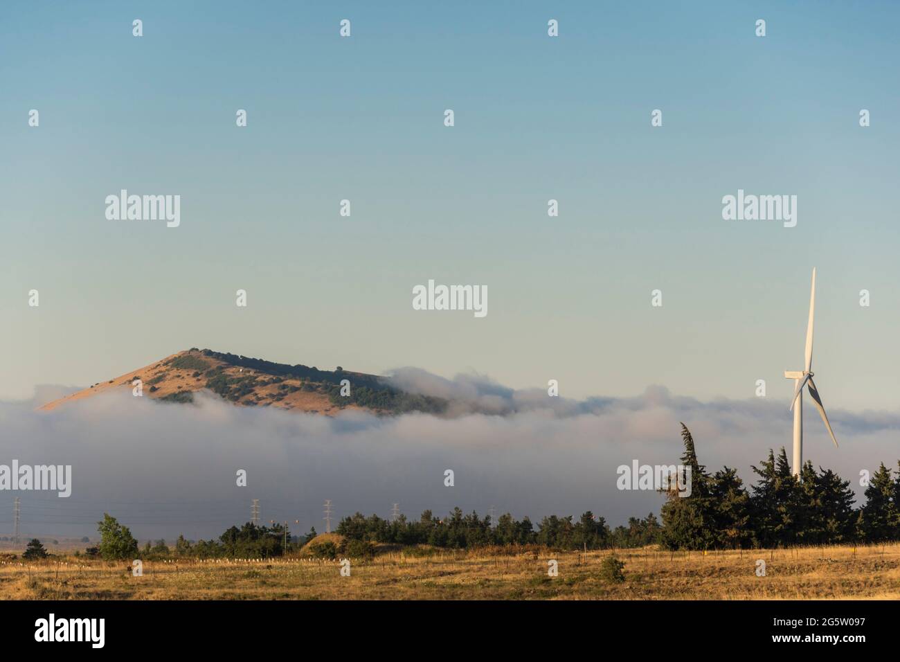 Golan Heights, Israel. Morning mist and wind turbines near the twin mountains of Avital and Bental. Stock Photo