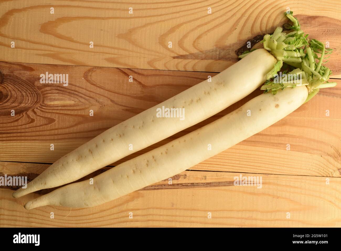 Two ripe organic radishes, close-up, on a wooden table, top view. Stock Photo