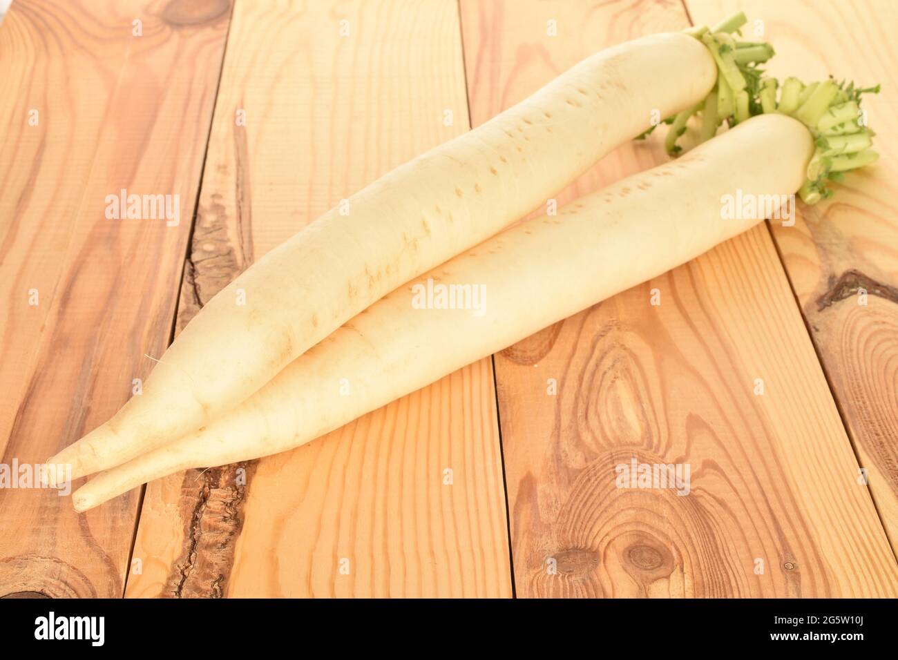 Two ripe organic radishes, close-up, on a wooden table. Stock Photo