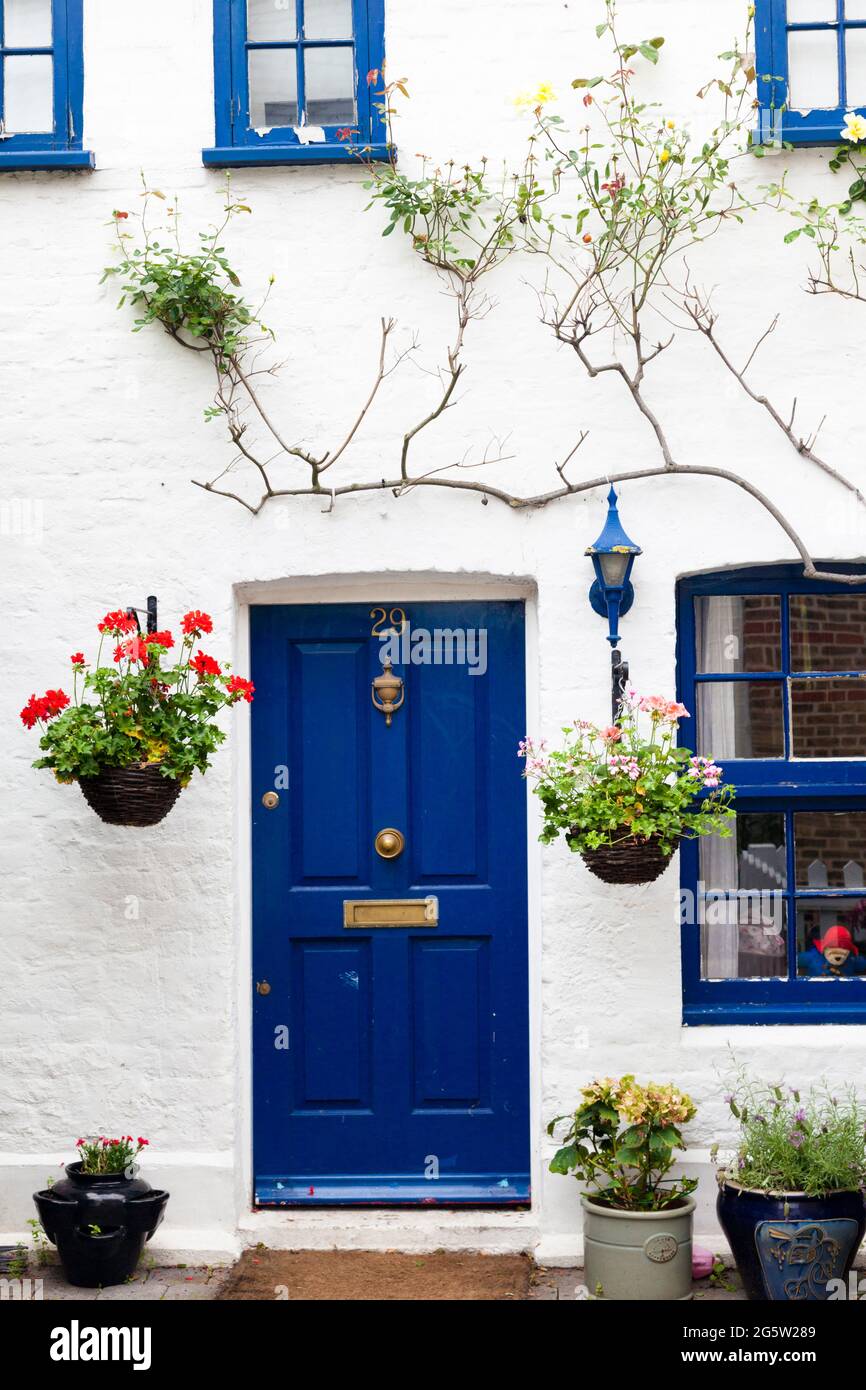 Street door to an urban cottage, with hanging baskets, UK. Stock Photo